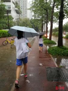 暴雨中的艰难上学路 家长纳闷：停课应看信号还是观风雨？